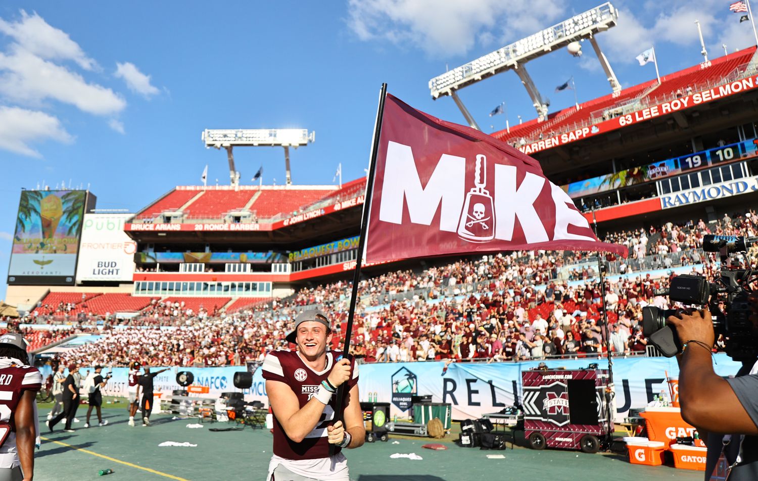 Mississippi State Bulldogs quarterback Will Rogers (2) carries a flag after they beat Illinois Fighting Illini in honor of there head coach Mike Leach in the 2023 ReliaQuest Bowl at Raymond James Stadium.
